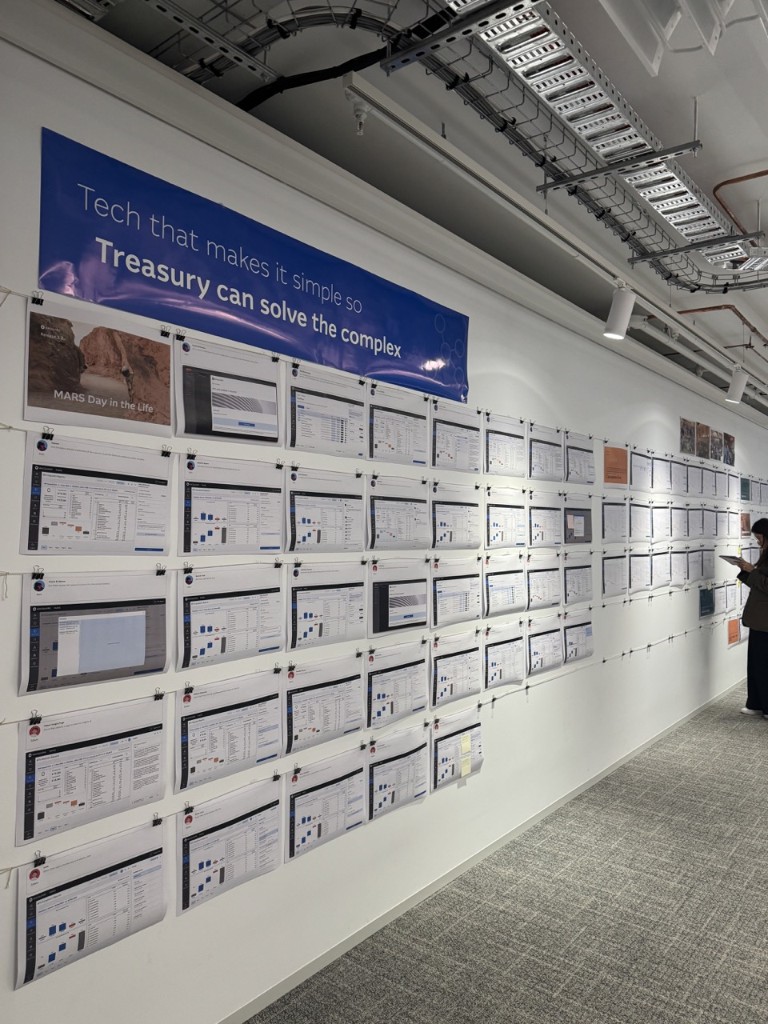Walk-the-wall: printed MARS screens clipped in rows along an office wall